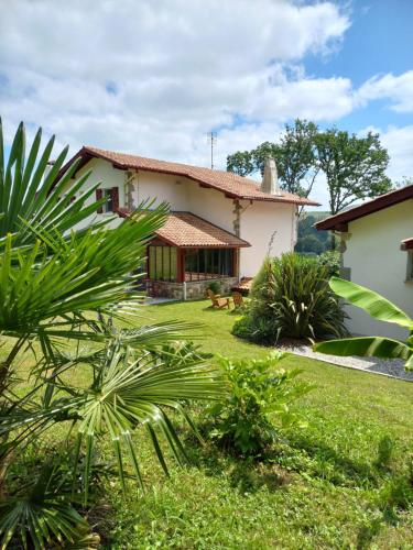 une maison avec un chien dans la cour dans l'établissement VILLA XARAN ERDIAN Chambres d'hôtes, à Espelette