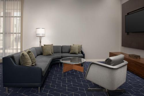 a living room with a couch and two chairs at Courtyard Syracuse Downtown at Armory Square in Syracuse