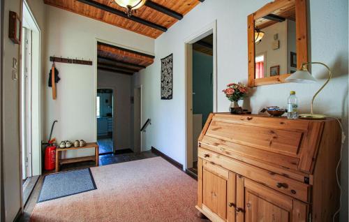 a bathroom with a wooden dresser and a mirror at Awesome Home In Åsljunga With Kitchen in Åsljunga