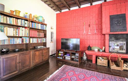 a living room with a red wall with bookshelves at Awesome Home In Åsljunga With Kitchen in Åsljunga
