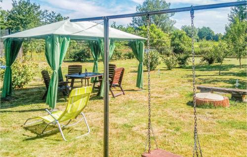 a swing in a yard with a table and chairs at Two-Bedroom Holiday Home In Osno Lubuskie in Ośno Lubuskie