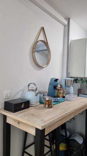 une table en bois avec un miroir sur le mur dans l'établissement Le Jardin des Bois, à Trosly-Breuil
