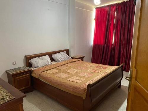 a bedroom with a bed with a red curtain at Happy Sweet Inn in Irbid