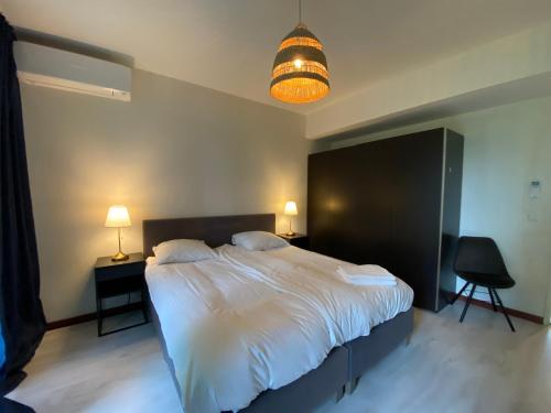 a bedroom with a large white bed and a lamp at Studio Amsterdam in Amsterdam