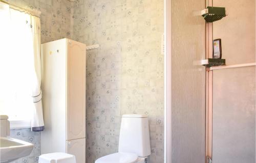 a bathroom with a white refrigerator and a toilet at Holiday Home Nordtveitgrend Nedrevågen in Haugen