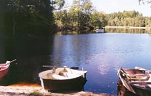 a boat sitting on the shore of a lake at One-Bedroom Holiday Home In Vittsjo in Vittsjö