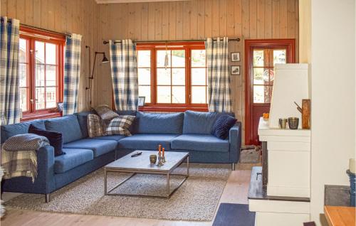 a living room with a blue couch and a table at Awesome Home In Rauland With Kitchen in Rauland