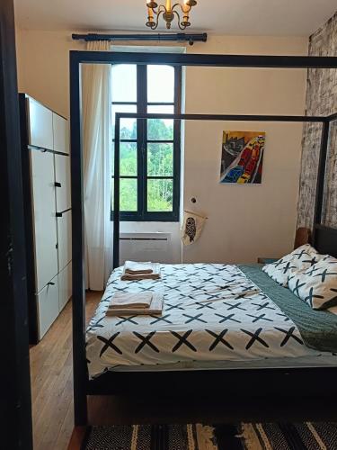 - une chambre avec un lit à baldaquin et une fenêtre dans l'établissement Les chambres des artistes, à Laguépie