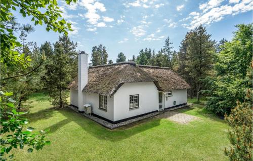 ein altes Haus mit einem Strohdach auf einem Hof in der Unterkunft Holiday Home Moritzvej Rømø Xii in Toftum
