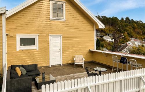 una casa gialla con una staccionata bianca e un patio di 3 Bedroom Awesome Home In Farsund a Farsund