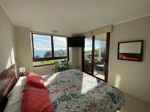 a bedroom with a bed and a large window at Departamento Puerto Velero in Tongoy