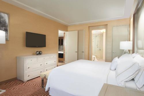 a bedroom with a white bed and a television at The Westin Las Vegas Hotel & Spa in Las Vegas