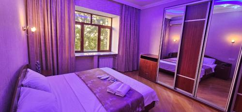 - une chambre violette avec un lit et un miroir dans l'établissement Apartment near seaside, à Baku