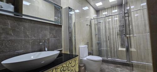 une salle de bain avec un lavabo, une douche et des toilettes dans l'établissement Apartment near seaside, à Baku