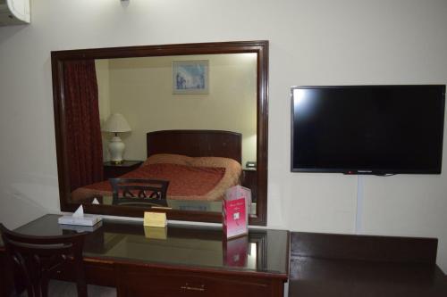 a bedroom with a bed and a large mirror at Carlton Tower Hotel Lahore in Lahore