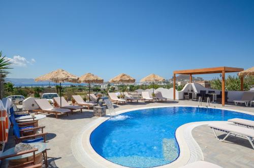 a pool at a hotel with chairs and umbrellas at Orama Apartments in Agia Anna Naxos