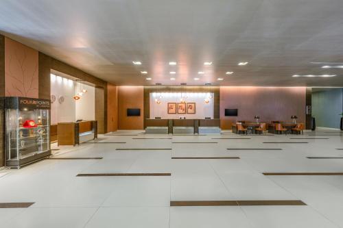 a lobby with tables and chairs in a building at Four Points by Sheraton Al Ain in Al Ain