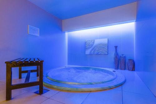 a large tub in a bathroom with a blue ceiling at Four Points by Sheraton Al Ain in Al Ain