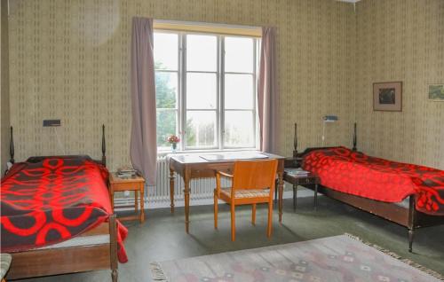 a bedroom with two beds and a desk and a table at 5 Bedroom Beautiful Home In Juskog Husa in Navarsviken