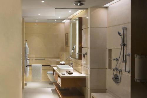 a bathroom with a sink and a shower at Courtyard by Marriott Kochi Airport in Nedumbassery