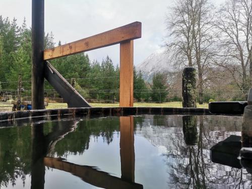 a playground with a wooden ramp and a pool of water at Cabaña Kiñeco in Melipeuco