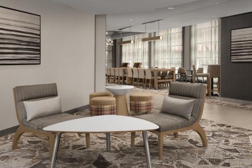 a living room with two chairs and a table at Residence Inn Syracuse Downtown at Armory Square in Syracuse