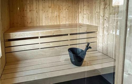 a sauna with a black bucket sitting on a wooden bench at 4 Bedroom Lovely Home In Sysslebäck in Sysslebäck