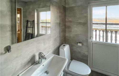 a bathroom with a sink and a toilet and a mirror at 4 Bedroom Lovely Home In Sysslebäck in Sysslebäck