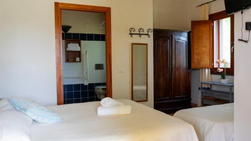 a bedroom with two beds with towels on them at Giardini Malaspina in Bosa