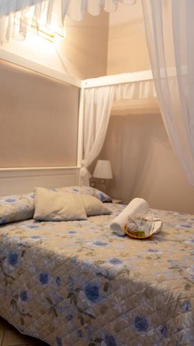 a bedroom with a bed with a blue floral bedspread at Giardini Malaspina in Bosa