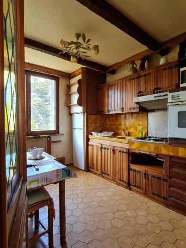 une cuisine avec des armoires en bois et une table à l'intérieur dans l'établissement Les Lauriers, à Saint-Raphaël