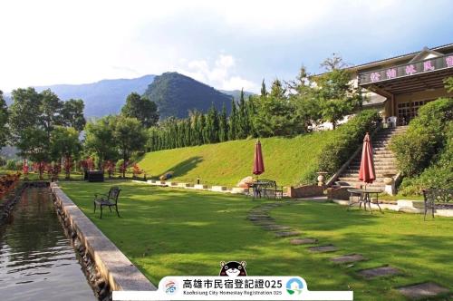 a dog laying on the grass next to a lake at Songboling Hot Spring Inn in Liugui