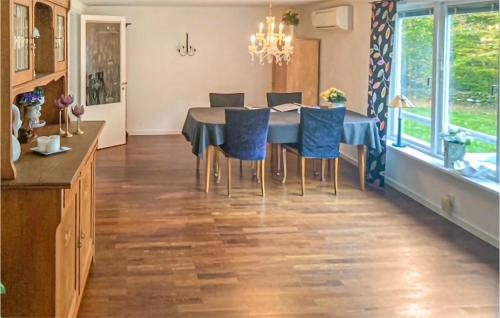 a dining room with a table and blue chairs at Beautiful Home In Hästveda With Kitchen in Askustorp