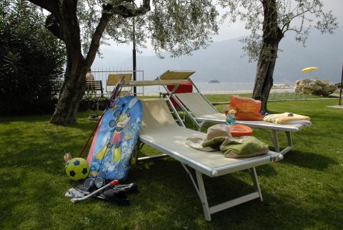 a picnic table and a swing set in the grass at Hotel Europa in Malcesine