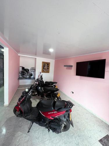 two motorcycles parked in a room with a flat screen tv at Tres habitaciones con Cuatro Aires acondicionados y Super lindo in Florencia