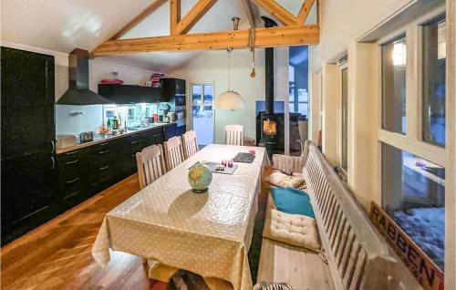 a dining room with a table and a kitchen at Amazing Home In Stamsund With Kitchen in Stamsund