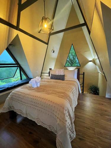 a bedroom with a large bed in a attic at Alma Luna Villa Arenal in Monterrey