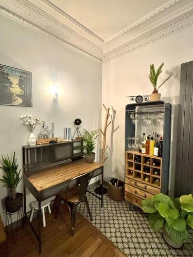 Cette chambre dispose d'un bureau et d'une table avec des plantes. dans l'établissement Apartment near Eiffel Tower Olympic games tickets, à Paris