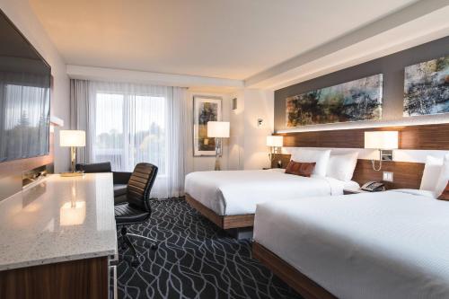 a hotel room with two beds and a desk at Delta Hotels by Marriott Waterloo in Waterloo