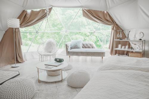 a bedroom with a tent with a bed and a table at NORTH GLAMPER 富良野 in Kami-furano