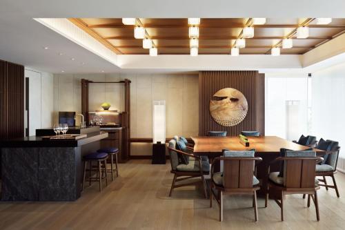 a dining room with a large wooden table and chairs at HOTEL THE MITSUI KYOTO, a Luxury Collection Hotel & Spa in Kyoto