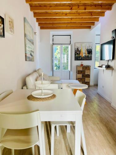 a dining room and living room with a table and chairs at Casa Roméo à 3 min de la plage in Sesimbra