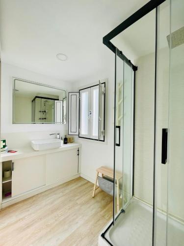 a bathroom with a glass shower and a sink at Casa Roméo à 3 min de la plage in Sesimbra