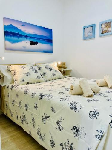 a bedroom with a bed with a blue and white comforter at Casa Roméo à 3 min de la plage in Sesimbra