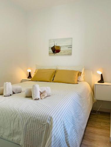 a bedroom with a large white bed with two pillows at Casa Roméo à 3 min de la plage in Sesimbra
