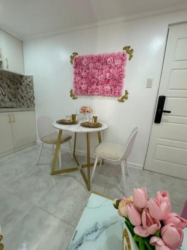 a dining room with a table and a pink painting on the wall at MAKATI Isabela Luxury in Manila