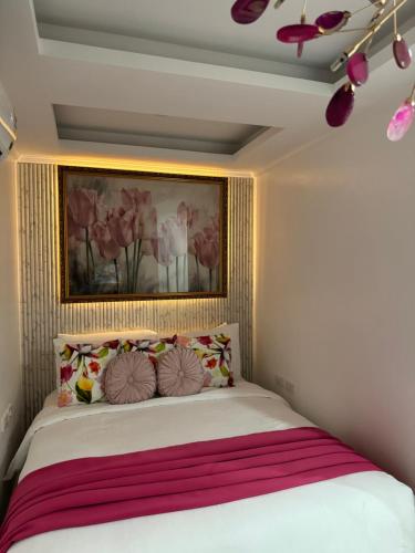 a bedroom with a bed with a painting on the wall at MAKATI Isabela Luxury in Manila