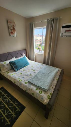 a bed sitting in a room with a window at Denise's Midtown Condo in Davao City
