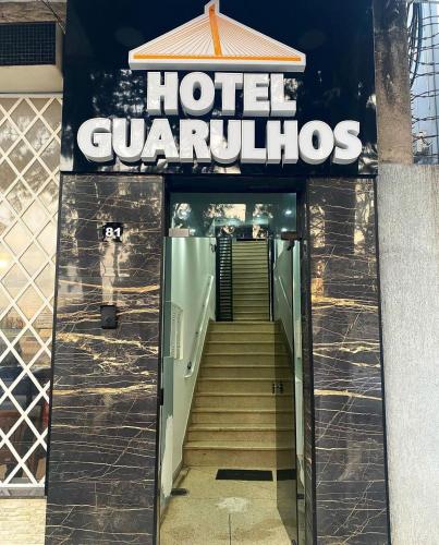 a hotel guatemolis sign with stairs leading into a building at Hotel Guarulhos in Sao Paulo