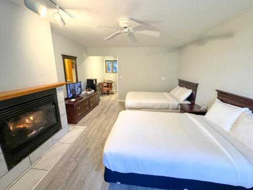 a hotel room with two beds and a fireplace at Lake Bluff Inn and Suites in South Haven